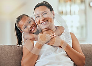 Love, hug and grandmother portrait with granddaughter bonding at home on the living room sofa. Mature woman embracing