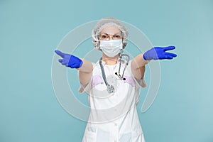 Love, hugs. Doctor or nurse woman in a personal protective suit with a stethoscope, on a blue background. In a mask