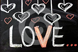 Love. I love you. Message of love. The inscription on the blackboard with chalk. Valentine`s day theme. Dark grunge texture backgr