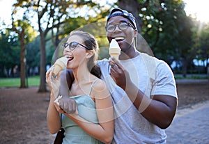 Love, ice cream or couple of friends in a park walking on a romantic date in nature in an interracial relationship