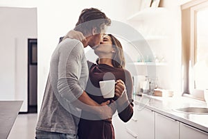 Love, intimate and kiss with a couple in the kitchen of their home together in the morning for romance. Kissing, passion