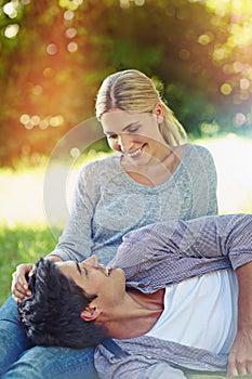 Love just fell into her lap. Shot of a happy young couple lying on the grass and sharing an affectionate moment together