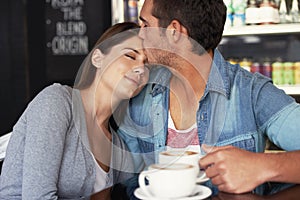 Love, kiss and couple drinking coffee in cafe, care and bonding together on valentines day date. Romance, man and woman