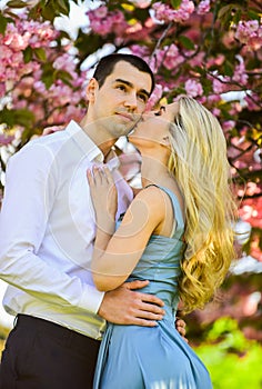 We love kissing. spring flower bloom. man and woman in park with pink blossoming cherry. beauty and fashion. sweet