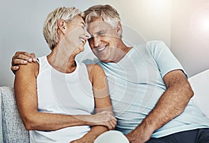Love, laughing and retirement with a senior couple sitting in the living room of their home together. Happy, smile or