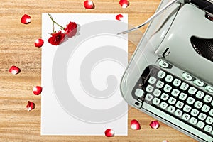 Love letter. Desk with blank paper, retro typewriter and red roses and petals