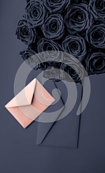 Love letter and flowers delivery on Valentines Day, luxury bouquet of roses and card on charcoal background for romantic holiday