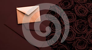 Love letter and flowers delivery on Valentines Day, luxury bouquet of roses and card on chocolate background for romantic holiday