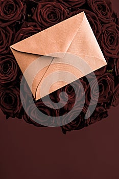 Love letter and flowers delivery on Valentines Day, luxury bouquet of roses and card on chocolate background for romantic holiday