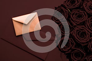 Love letter and flowers delivery on Valentines Day, luxury bouquet of roses and card on chocolate background for romantic holiday