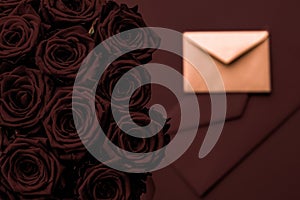 Love letter and flowers delivery on Valentines Day, luxury bouquet of roses and card on chocolate background for romantic holiday