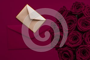 Love letter and flowers delivery on Valentines Day, luxury bouquet of roses and card on maroon background for romantic holiday