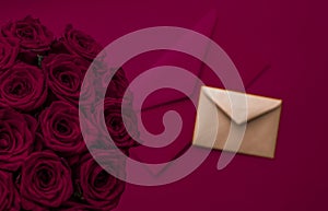 Love letter and flowers delivery on Valentines Day, luxury bouquet of roses and card on maroon background for romantic holiday