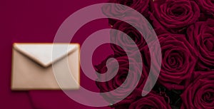 Love letter and flowers delivery on Valentines Day, luxury bouquet of roses and card on maroon background for romantic holiday