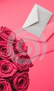Love letter and flowers delivery on Valentines Day, luxury bouquet of roses and card on pink background for romantic holiday