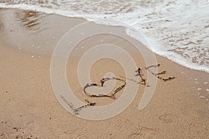 Love lettering on the sandy beach and sea water