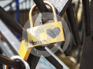 Love lock as a symbol of love and unity hanging on a bridge railing