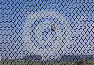 Love Lock on chain link fence with blue sky in background