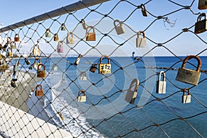Love locks on bridge fence in front of the sea