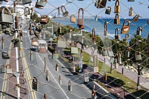 Love locks on metal fence in front of the street