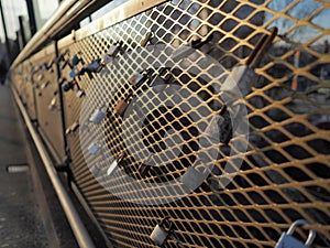 Love locks padlocks on bridge fence during sunset warm color