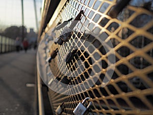 Love locks padlocks on bridge fence during sunset warm color