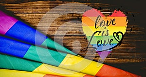 Love is love text and rainbow flag over wooden boards