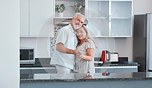 Love, marriage and dance with a senior couple in the kitchen of their home together for bonding or romance. Portrait