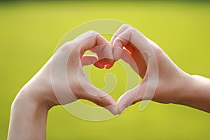 Love meaning gesture make a gesture with woman hand green lawn grass as background