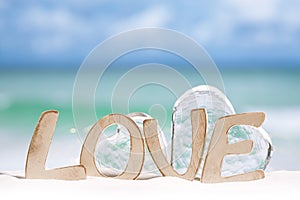 Love message and glass hearts on beach