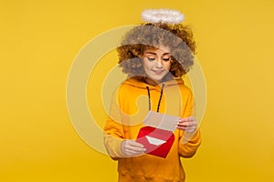 Love message. Portrait of curly-haired angelic woman with nimbus reading letter or greeting card