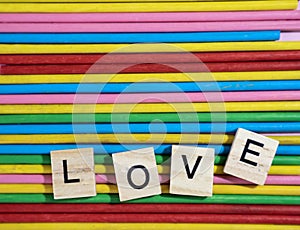 Love message written in wooden blocks placed on colourful wood s