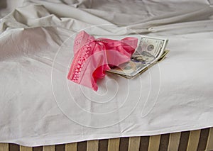 Love for money is prostitution. Crumpled bed, underwear and money as payment for sex photo