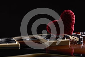 love music concept. electric guitar with red heart on it. dark moody shot. copy space