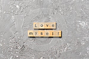 Love myself word written on wood block. Love myself text on cement table for your desing, Top view concept