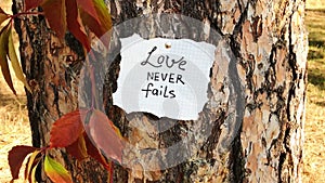 Love never fails - card with biblical quote, christian lettering on card
