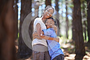 We love the outdoors and each other. Portrait of a mother and son embracing while enjoying a day outdoors.