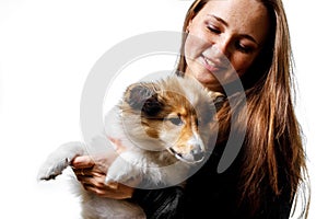 Love between owner and dog. Girl and sheltie puppy