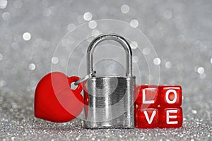 Love padlock against a silver-toned glittery background photo