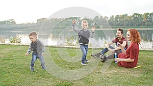 Love and parenthood concept. Happy Family with children blow soap bubbles outdoors