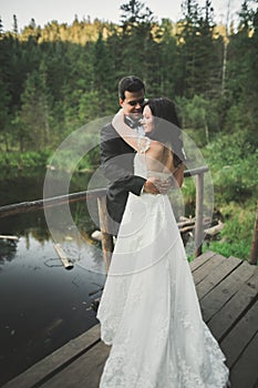 Love and passion - kiss of married young wedding couple near lake