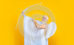Love, passion, valentines day concept. Bearded man in angel costume with bow and arrows. Valentines day cupid in angel