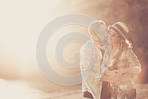 Love people and relationship adult couple concept with man and woman whispering and kissing each other outdoor during a coloured