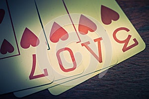 Love, poker playing cards with heart symbol that form the written love