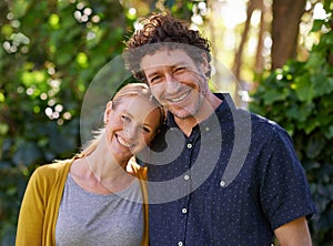 Love, portrait and happy couple hug in a park for fun, bonding or vacation together in nature. Travel, face and people