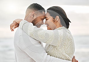 Love is pure. an affectionate young couple sharing an intimate moment on the beach.