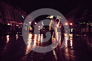 Love in the rain / Silhouette of kissing couple under umbrella