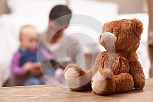 Love, reading or father and baby with book in a bedroom for reading, bonding or playing with teddy bear blur. Family