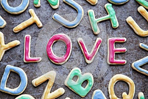 Love in red icing amongst letter shaped cookies, close-up