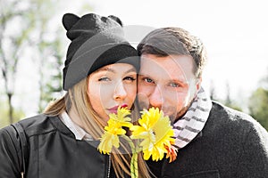 Love, relationship, family and people concept - couple with bouquet of gerberas in autumn park